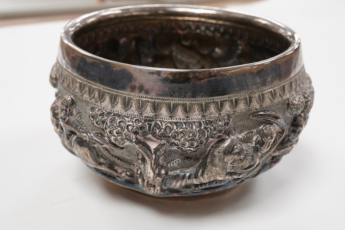 A late 19th/early 20th century Burmese white metal bowl, embossed with figures and animals in continuous battle scene, top diameter 12.4cm.